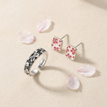 The Hanami Set — Sakura Ring Komorebi and The Sakura Essence Studs on an ivory backdrop
